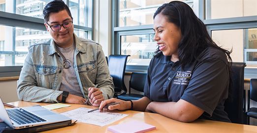 A staff member confers with a student.