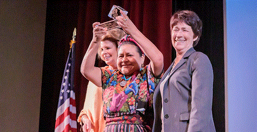 Rigoberta Menchú Tum holds up the Alice & Clifford Spendlove Prize for Social Justice, Diplomacy and Tolerance.